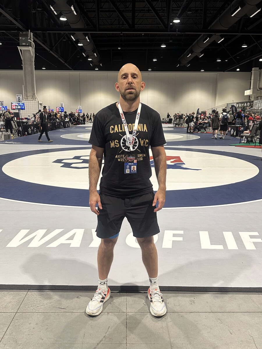 Chris on the wrestling mat with a medal